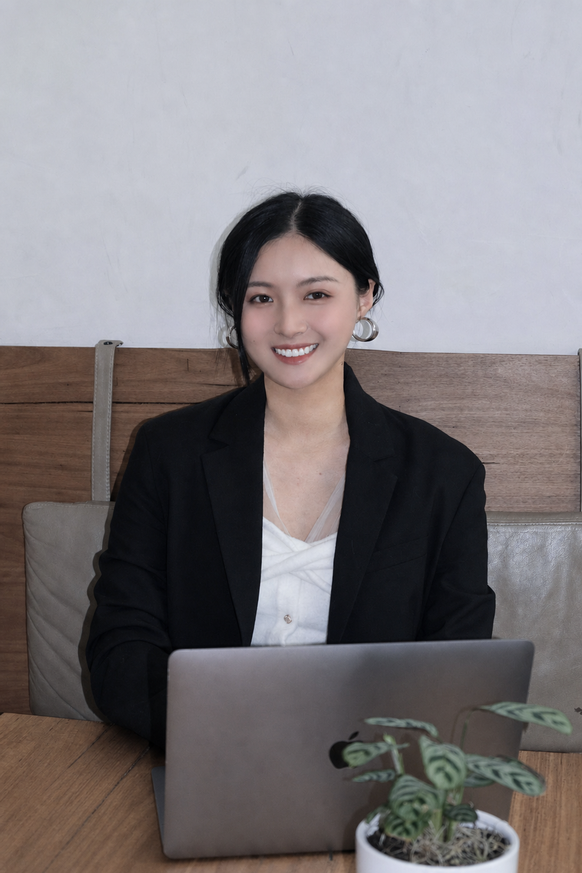 Lena 坐在工作室内的肖像，桌上放着电脑和绿植